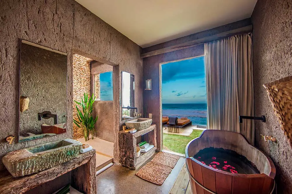 Bathroom in a Kenoa suite, eco-chic style, stone sinks and an ofuro tub with ocean views