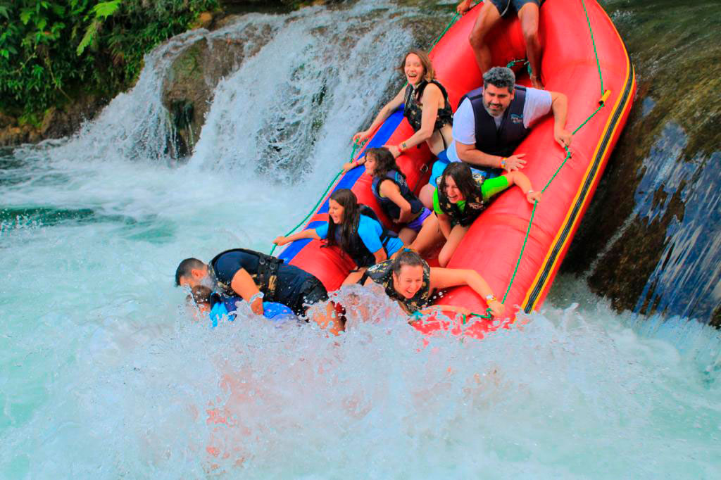 Macuco Safari boat tour under Iguazu Falls, Brazil – tourists in raincoats getting close to the cascades