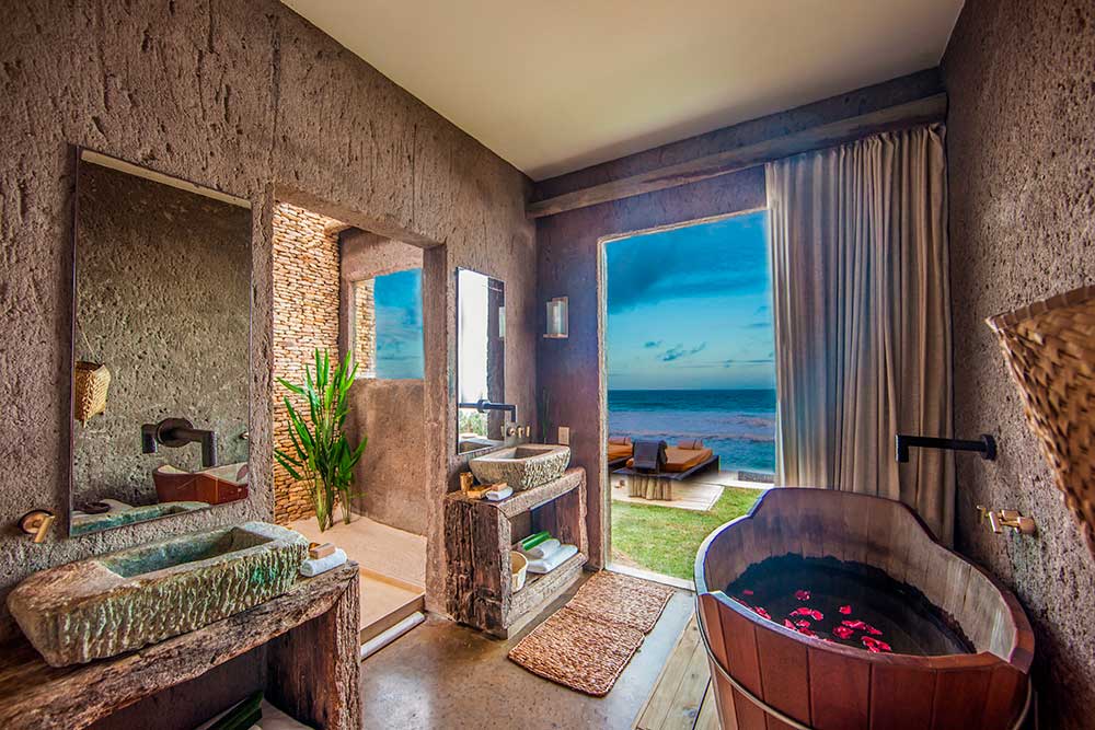 Bathroom in a Kenoa suite, eco-chic style, stone sinks and an ofuro tub with ocean views