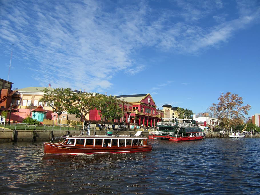 Colorful riverside buildings and tour boats on the Tigre river delta near Buenos Aires.