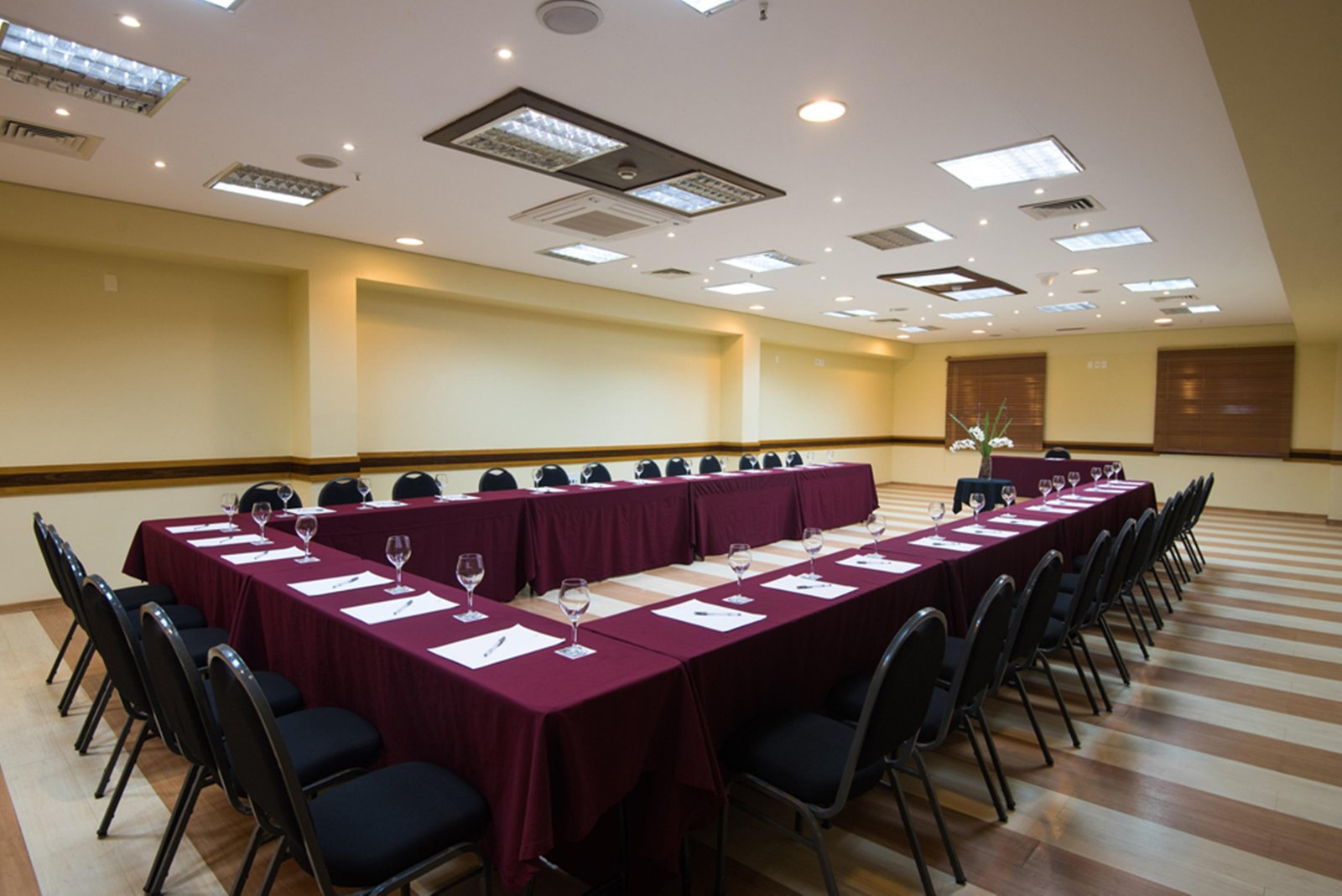 An empty meeting room in Fortaleza with a U-shaped table, chairs and prepared stationery.