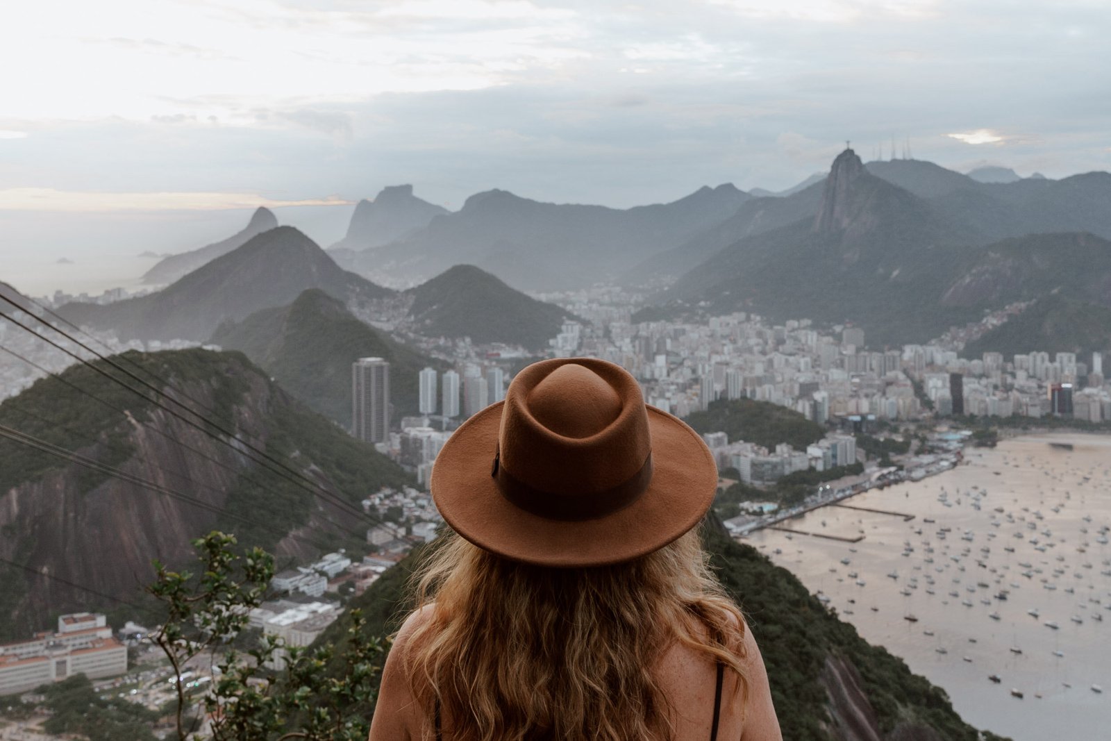 A traveller looks toward Rio and Guanabara Bay from an elevated viewpoint.