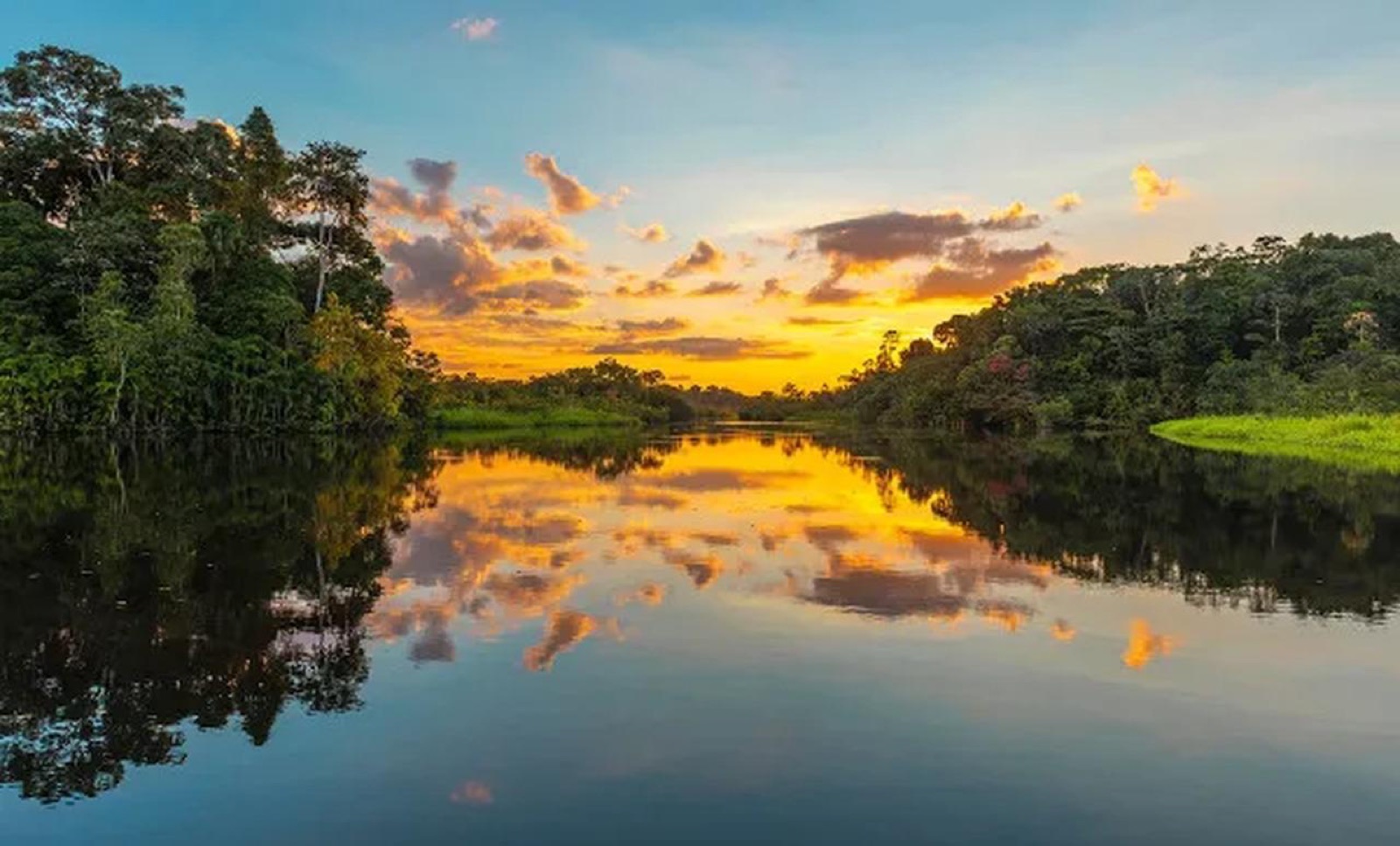 Sunset reflected on a forest-lined Brazilian river