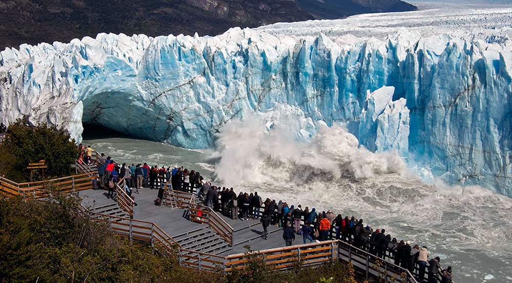 Visitors on a viewing platform watching ice calve from the Perito Moreno Glacier near El Calafate.
