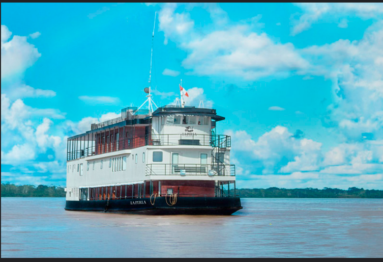 Travellers on a small boat on a forested Amazon river