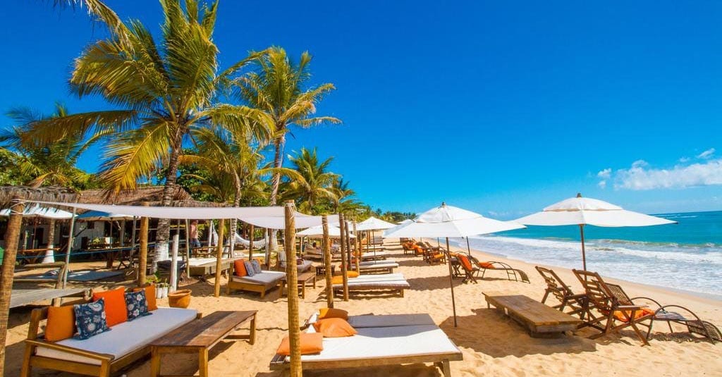 Shaded loungers and umbrellas at a beach club in Trancoso, Bahia.