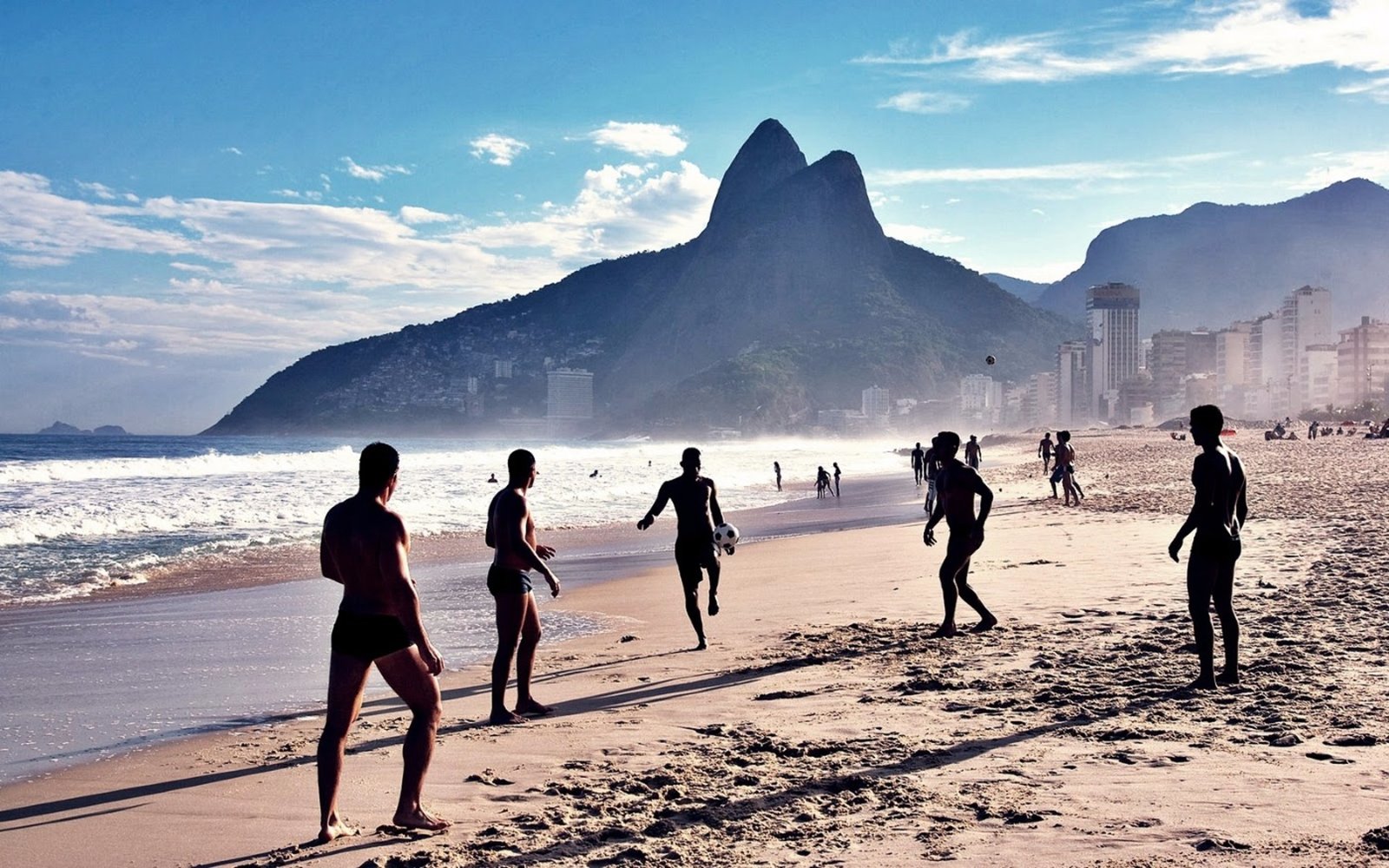 Beachgoers on Ipanema beach in Rio, with mountains behind.