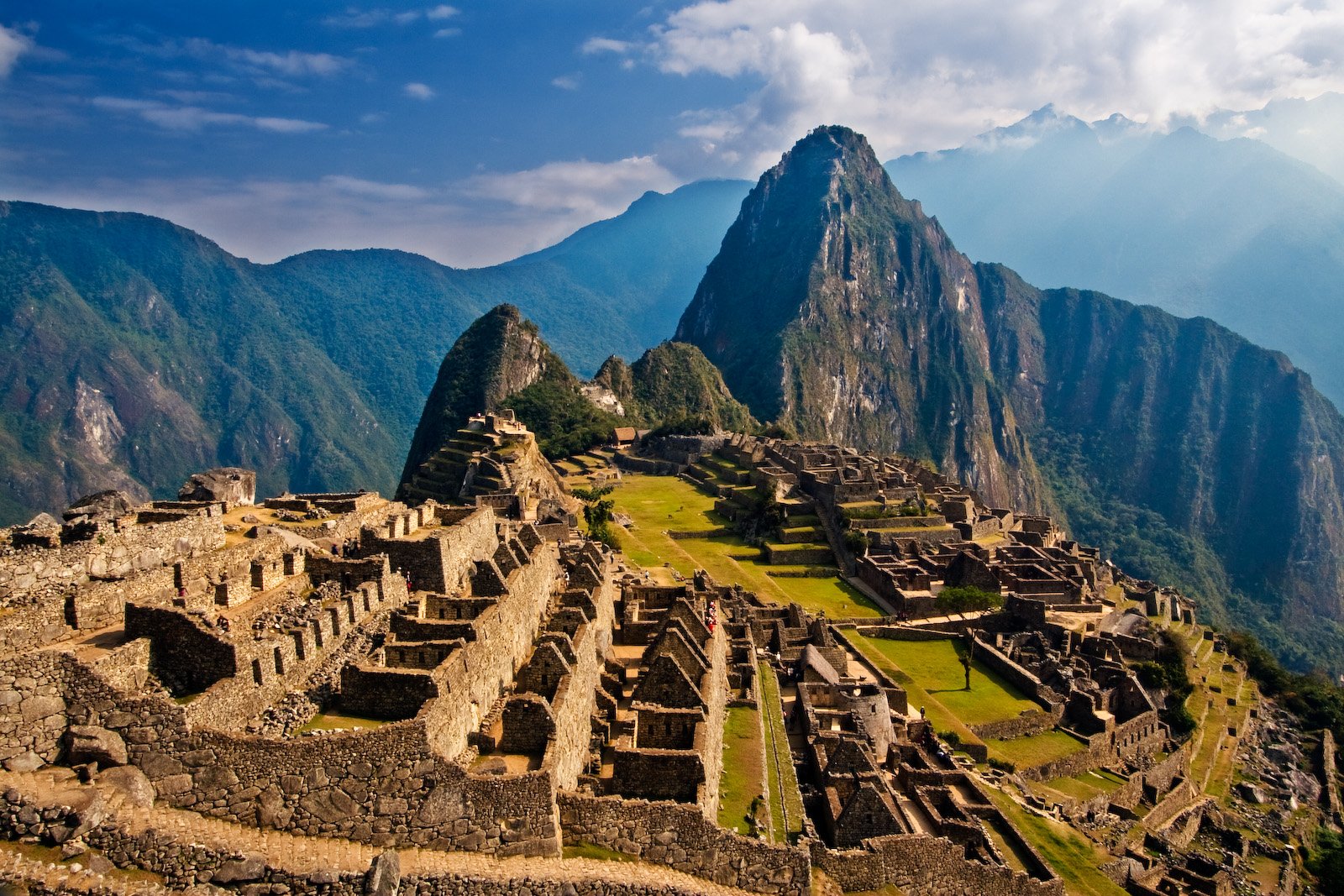 Machu Picchu's stone terraces and ruins beneath Huayna Picchu peak, seen from the classic overlook.
